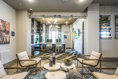 a living room with chairs and a table and a dining room